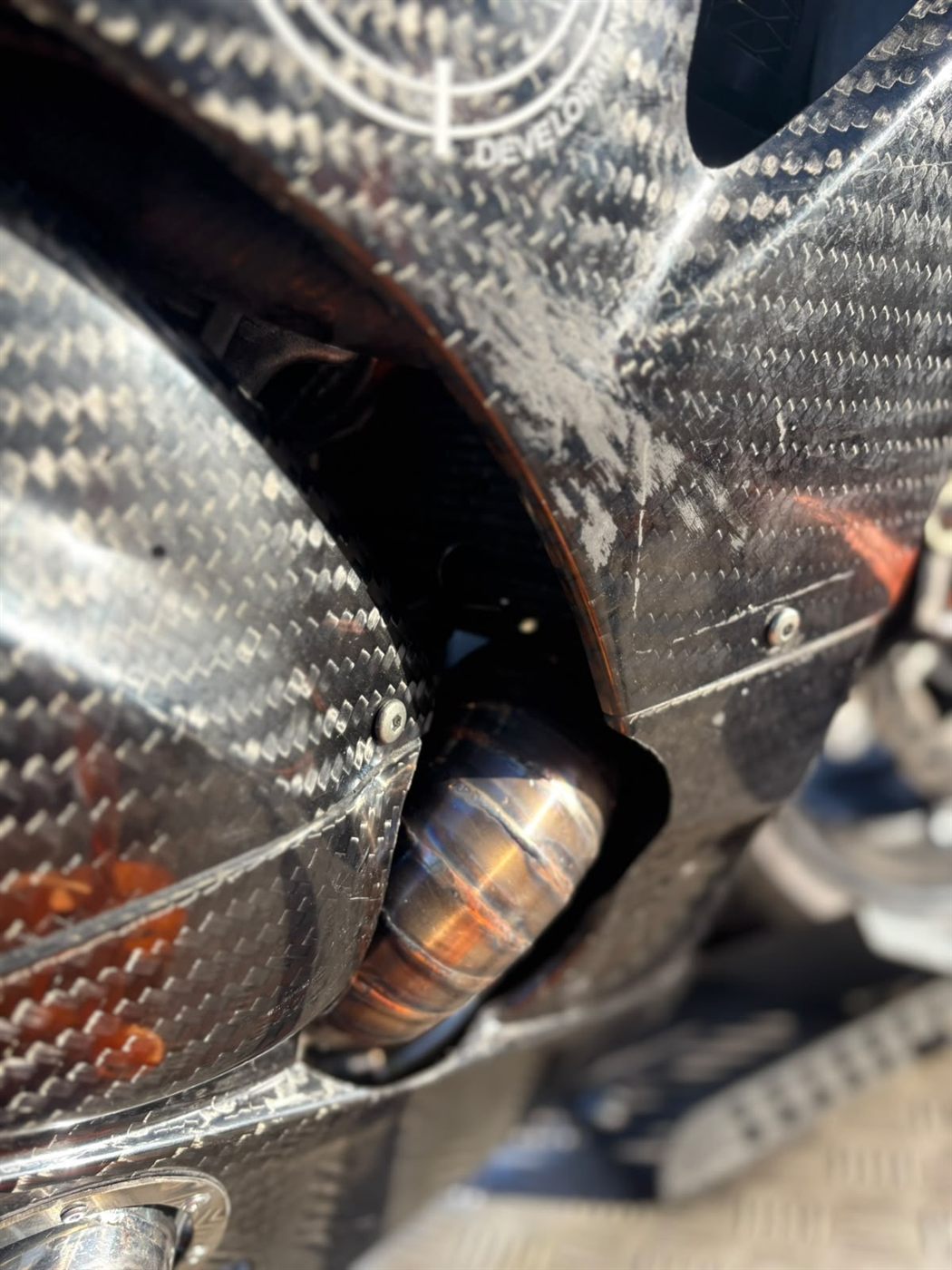 Exhaust tip exiting a carbon rear diffuser