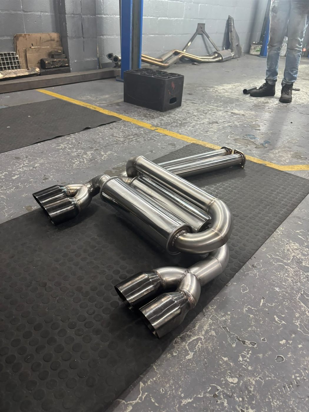 Mufflers and tips laid out on the workshop floor